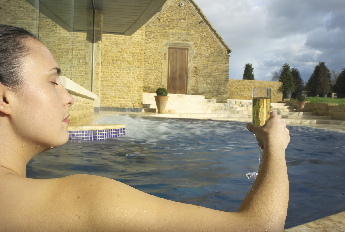 Woman in a pool with a glass of champagne