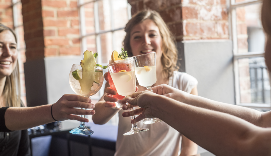 group of women toasting with cocktails