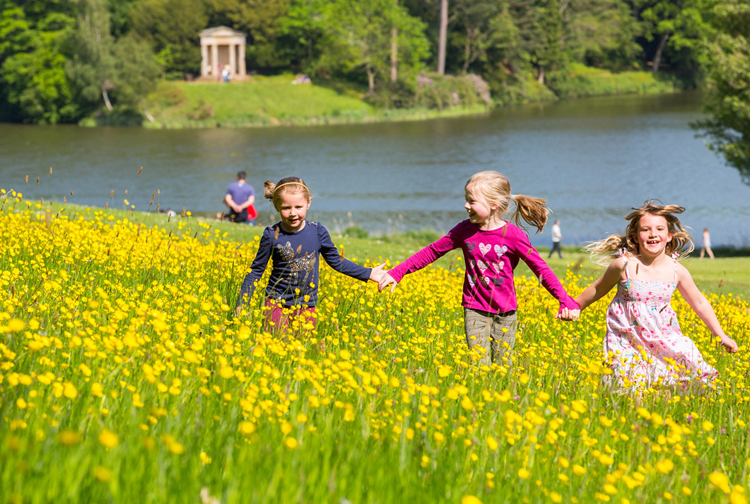 Children running through fields at Bowood in Wiltshire