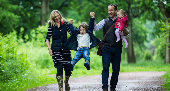 family with small children walking through woodland